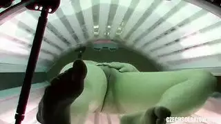 فتاة مثيرة تلمس نفسها في كابينة التسمير